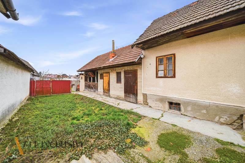 A family house in Topoľníky with a courtyard, garden, and traditional facade.