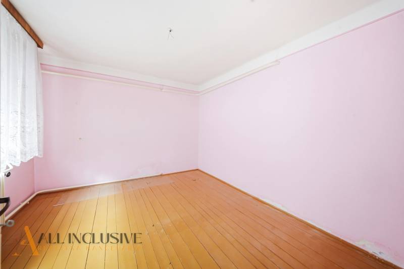 A room with pink walls and a wooden decor floor in a family house.