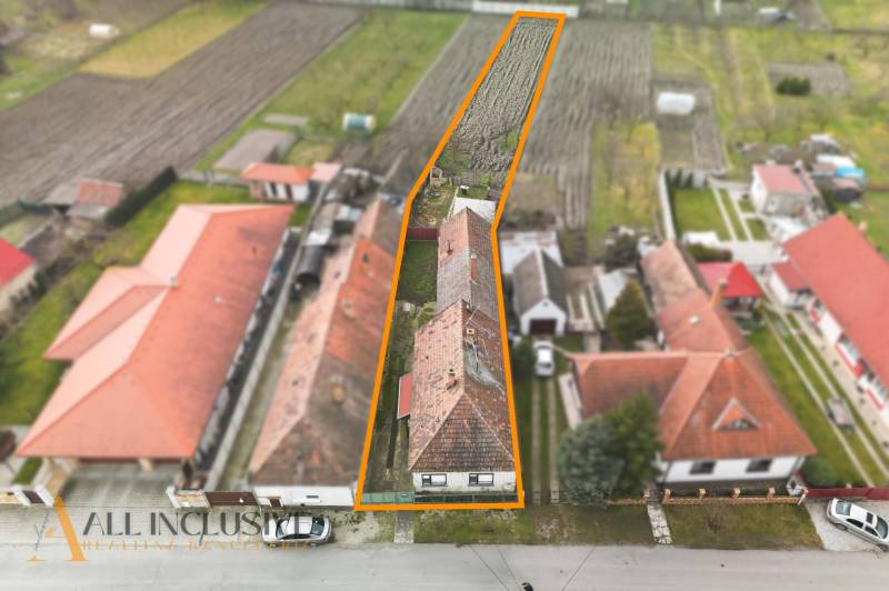 A family house in Topoľníky with a large plot, surrounded by the roofs of neighboring houses.