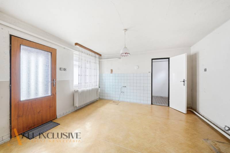 The interior of a family house with a wooden decor floor and white walls.