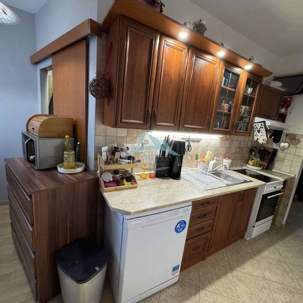 A kitchen in a 3-room apartment with wooden cabinets and appliances, a floor with a wooden decor.