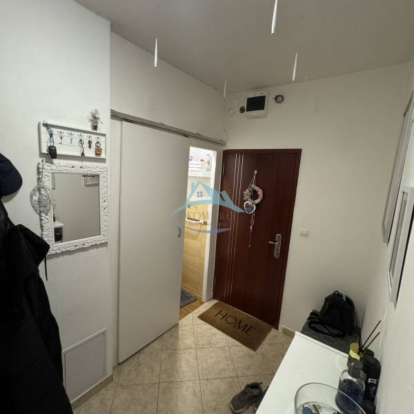 Hallway of a 3-room apartment with coat racks, a mirror, and entrance doors.