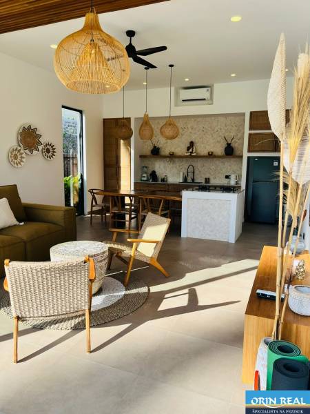 Interior of a family house with wicker accessories and a kitchen, floor with wooden decor.