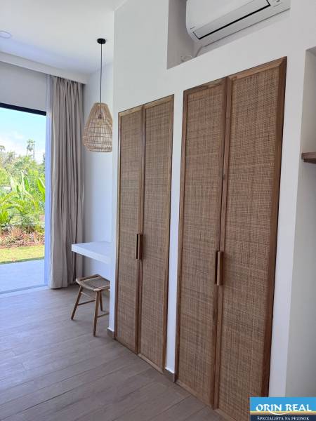 Interior of a family house with a wooden decor floor and rattan elements.