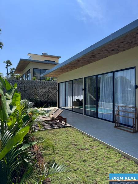 The garden of a family house in Amede with glass and loungers on the terrace.