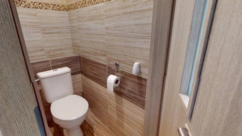 A bathroom with walls featuring a wooden decor in a 2-room apartment.