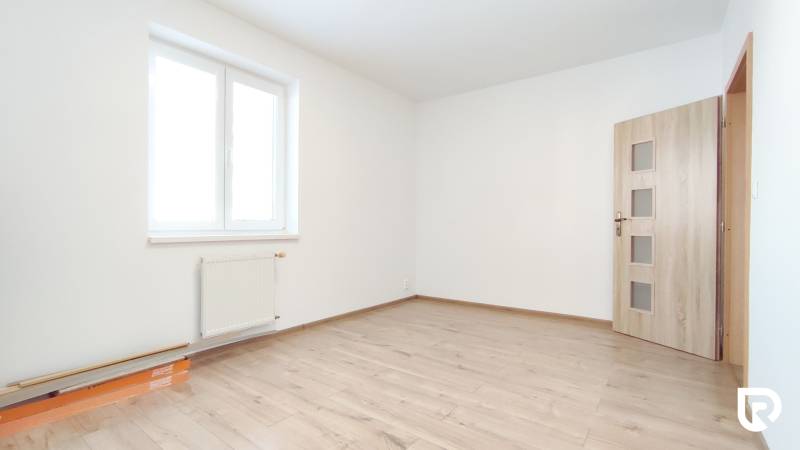 A bright room with a wood-decor floor in a two-room apartment.