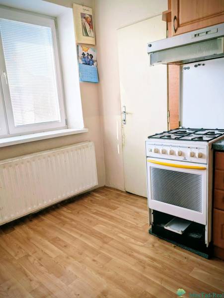A kitchen in a family house with a gas stove and a wooden decor floor.