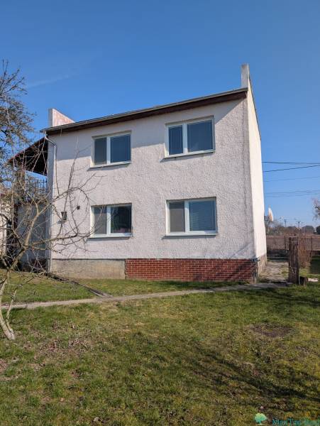 A family house in Lastovce on Nova Street with a white facade and a garden.