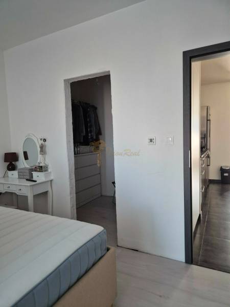 Bedroom with a mirror, entrance to the wardrobe, and hallway in a 3-room apartment.