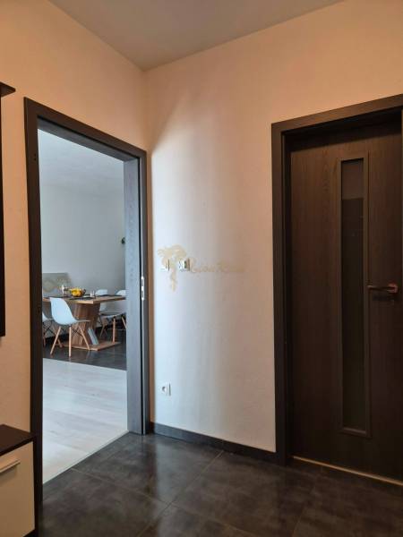 A hallway in a 3-room apartment with doors and a view into the dining room.