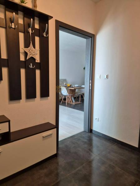 A hallway with folding furniture and a view into the dining room in a 3-room apartment.