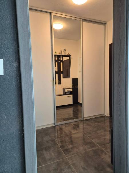 A hallway in a 3-room apartment with tiles and a built-in wardrobe.