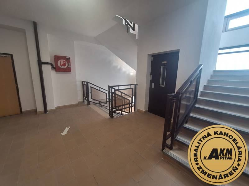 Staircase in offices with tiles and an elevator. Emergency box on the wall.
