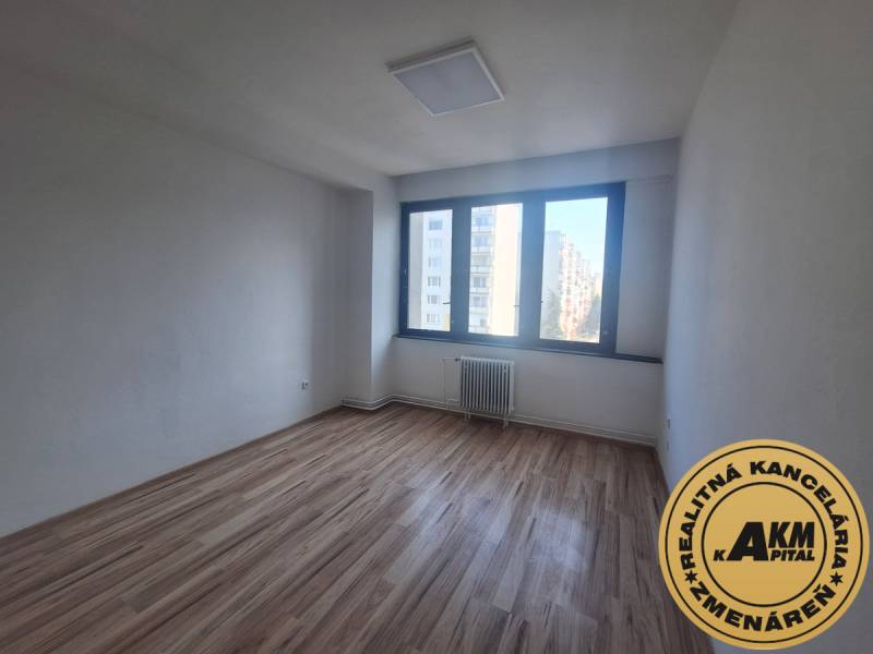Office room with wood-patterned flooring and a large window on Tulská Street in Zvolen.