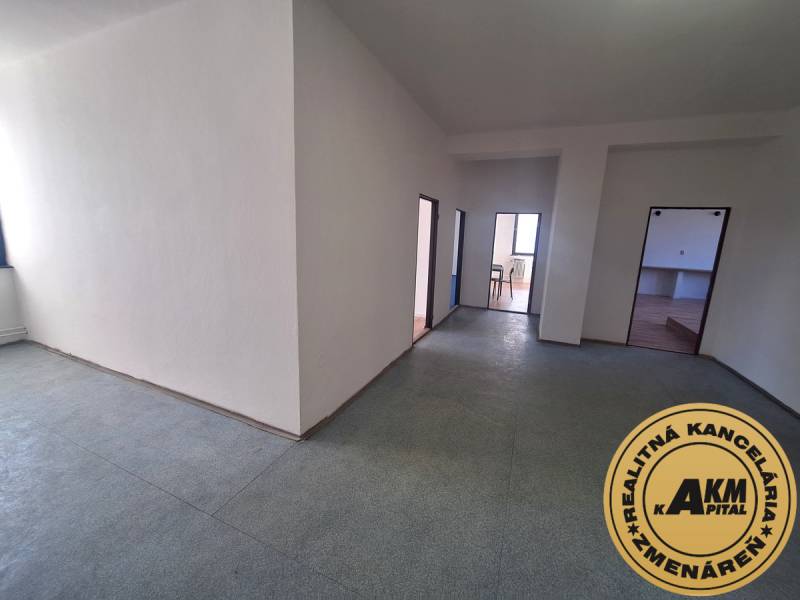 Open office space with white walls and linoleum flooring.