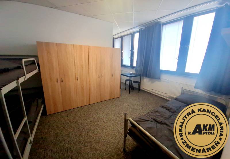 Furniture in the interior of a building with beds, a wardrobe, and a table on a carpet.