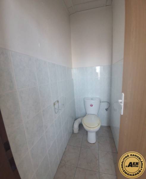 A restroom in a building with ceramic tiles and flooring.