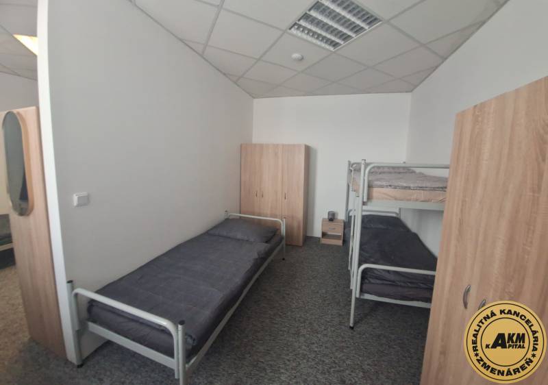 The interior of a building with beds and wardrobes, a floor with wooden decor.