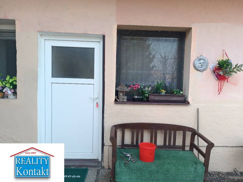 Entrance to a one-room apartment with a bench and floral decorations.