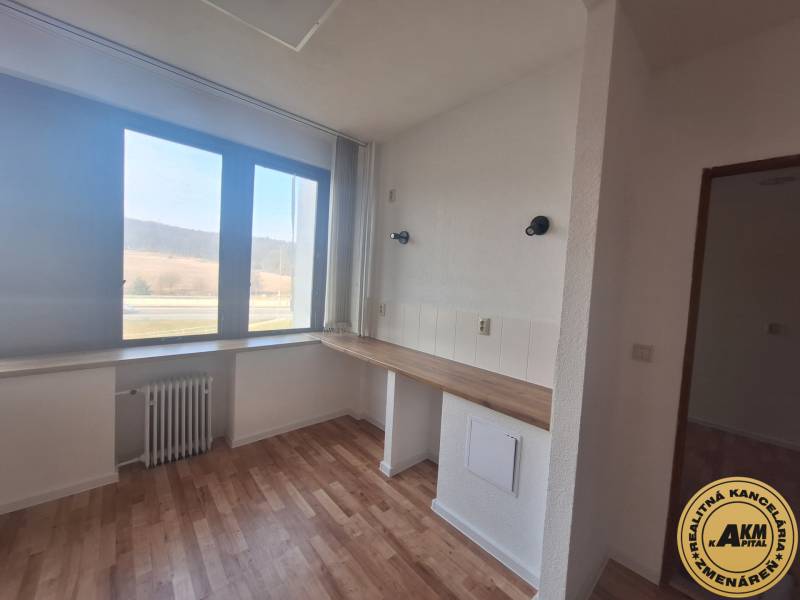 Commercial premises with wood-patterned flooring and a large window.