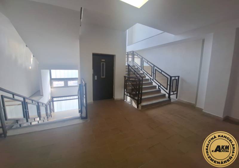 A staircase in commercial premises with windows and a wooden decor floor.