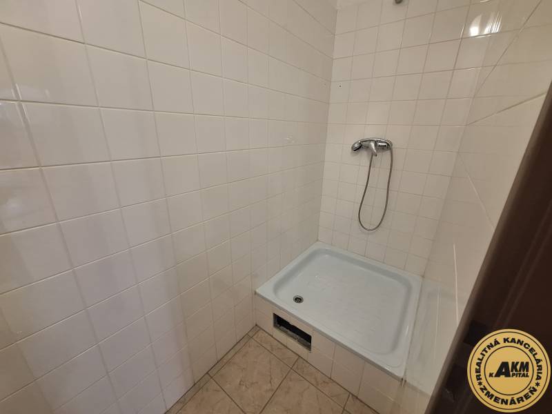 Shower corner with white tiles in commercial premises.