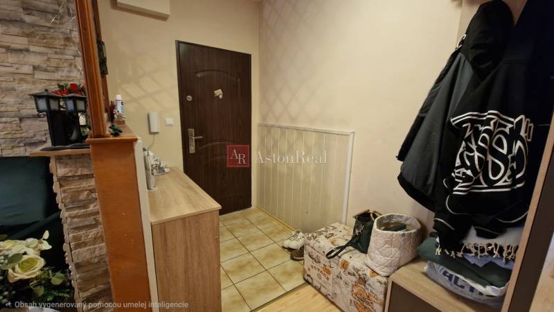 Entrance hall in a 3-room apartment with stone cladding and storage spaces.