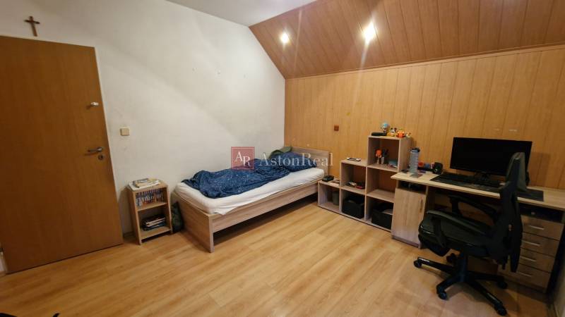A room in a 3-room apartment with a bed, a desk, and a floor with a wooden decor.