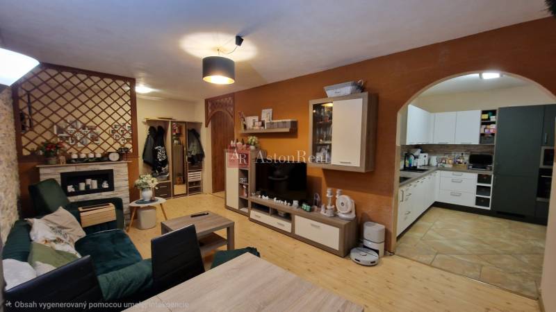 Living room in a three-room apartment with a wooden decor floor and an open kitchen.