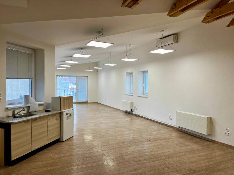 Offices with wood-patterned flooring and a kitchenette, ceiling lighting.