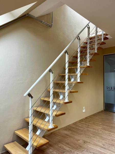 A staircase with wooden steps and railing, a floor with a wooden decor in the office.
