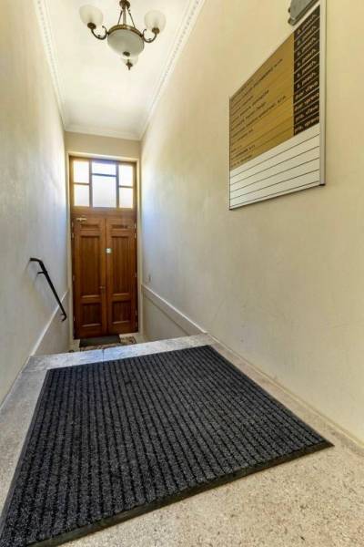 A narrow staircase with a ladder and a lamp leads to a wooden door. Offices.