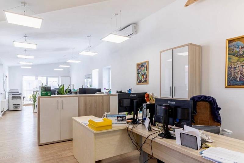 Offices with wood-patterned flooring, work desks, and storage cabinets.