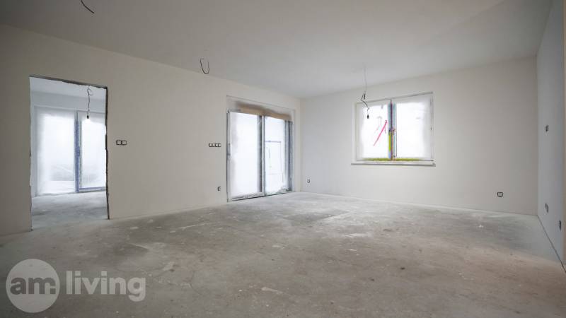 A room in a family house with unfinished floors and walls, without furnishings.