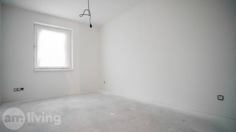 Empty room with white walls and a bright window in a family house.