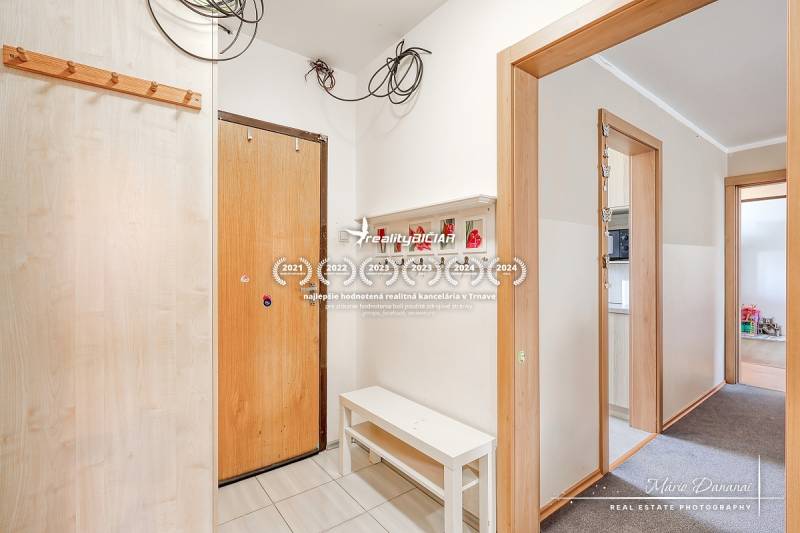 Entrance hallway in a 4-room apartment, white walls, coat hooks, and a bench.