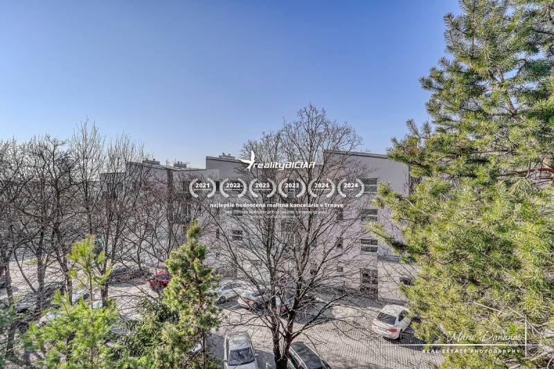 A view of Veterná Street in Trnava from a 4-room apartment, showing trees and cars.
