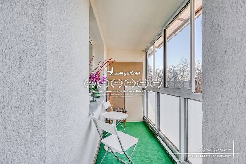 Enclosed balcony with green carpet in a 4-room apartment.
