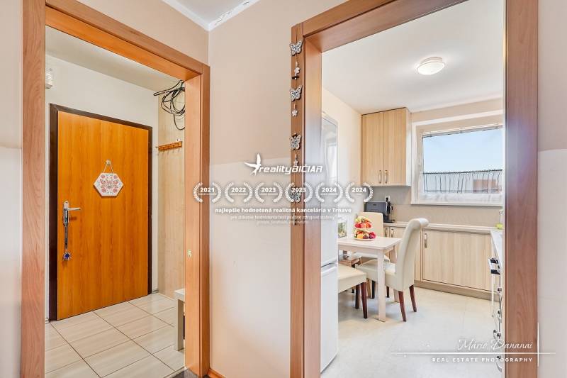 Interior of a 4-room apartment with a wooden decor floor and a light kitchen.