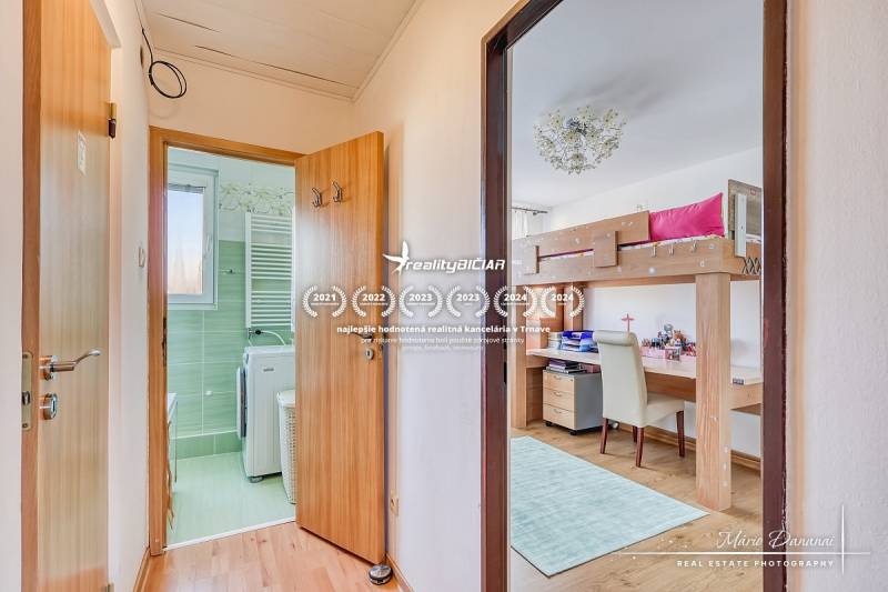 A hallway with a bathroom and a children's room in a 4-room apartment, flooring with a wooden decor.