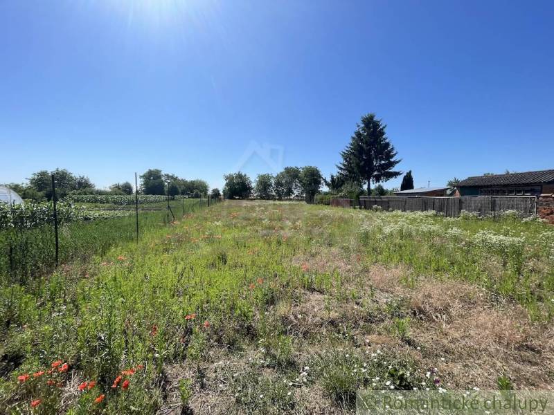 A plot of land near a family house in Tvrdošovce with fencing and greenery.