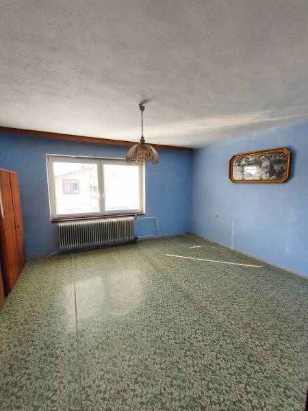 Interior in a family house with a blue wall, carpet, and pendant light.