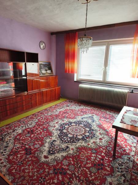 Purple walls and a luxurious chandelier adorn the room in the family house with a striking carpet.