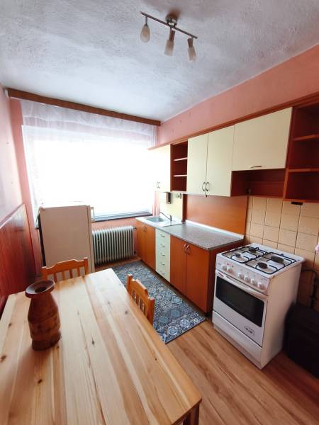 A kitchen in a family house with a wooden floor decor, a gas stove, a dining table.