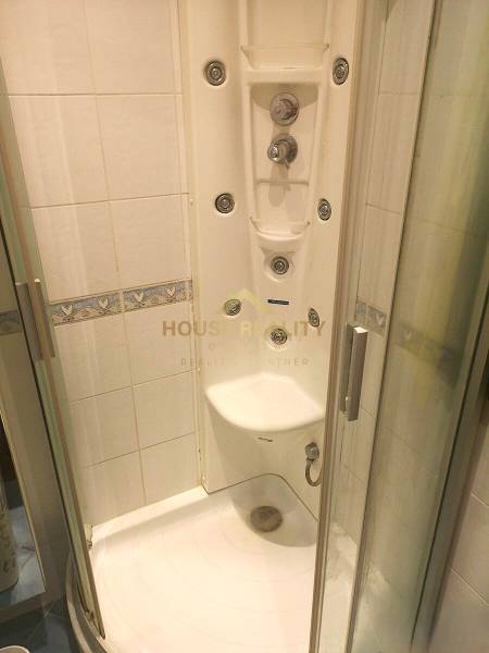 A shower cabin with hydromassage jets in a 2-room apartment.