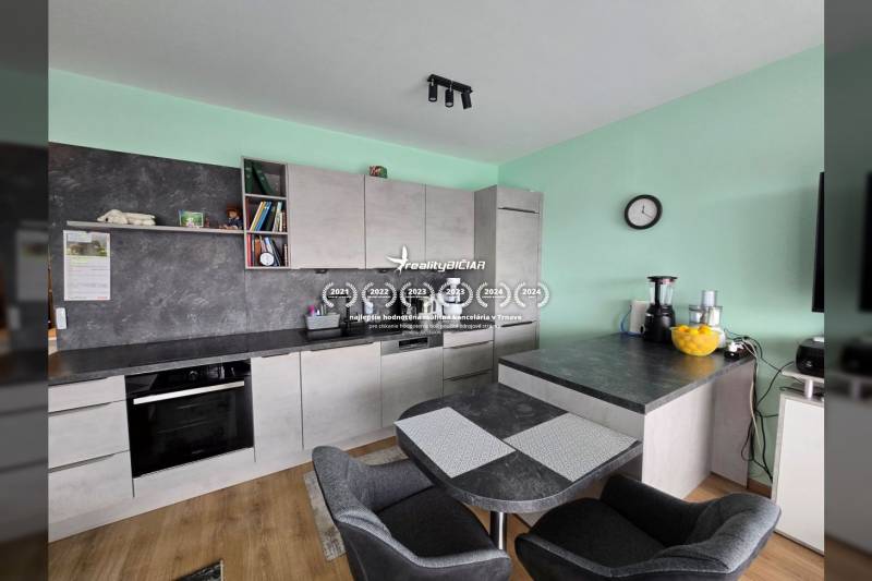 A kitchen with a dining table and a wooden decor floor in a Holiday Apartment.