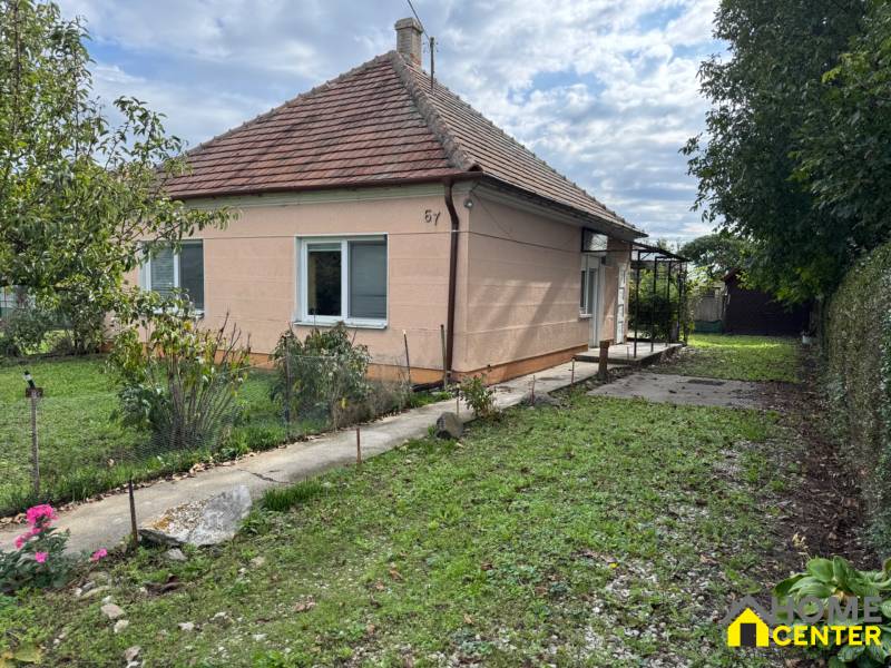 Family house in Komárno with a grassy garden and trees on a landscaped plot.