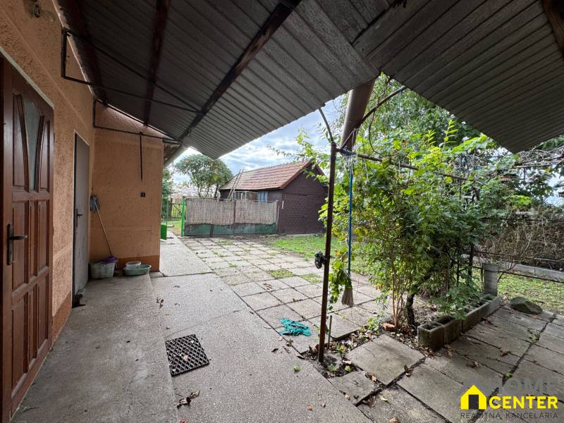A family house in Komárno with a spacious yard and a gazebo, surrounded by greenery.