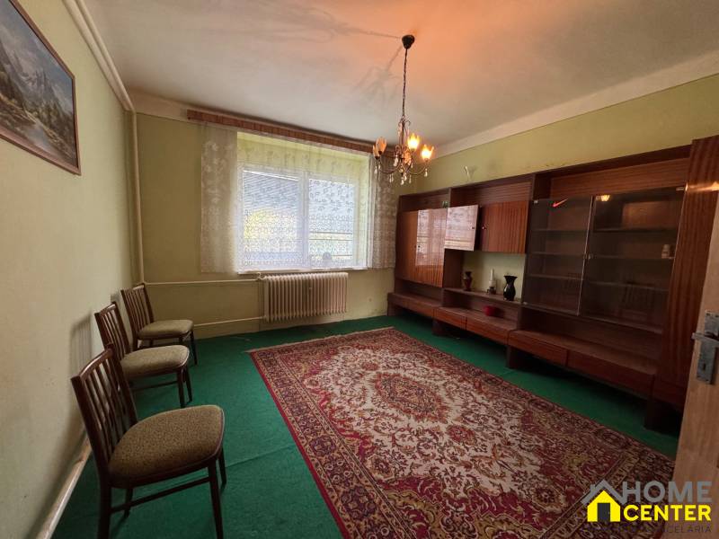 Living room with carpet and furniture in a family house, softly lit by a chandelier.